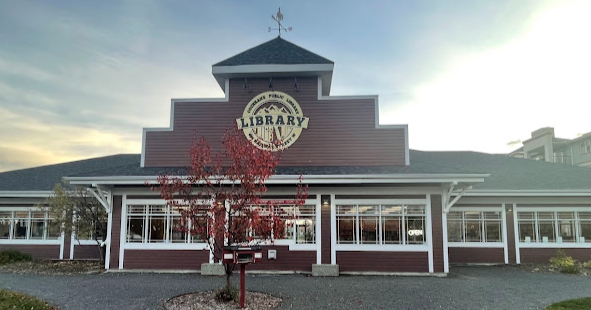 image of front of the red Cochrane Public Library building with a tree in front. 