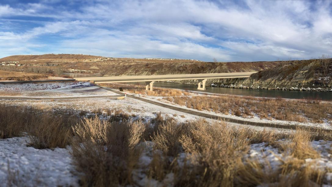 Aerial view of Jack Tennant Memorial Bridge. The bridge connects two hills and crosses over a river.