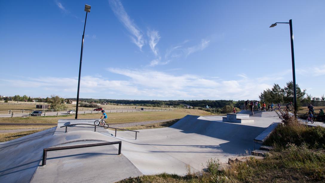 Kid riding bike through a skate park 