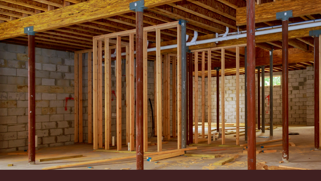 Unfinished basement framed with three support posts supporting the structure