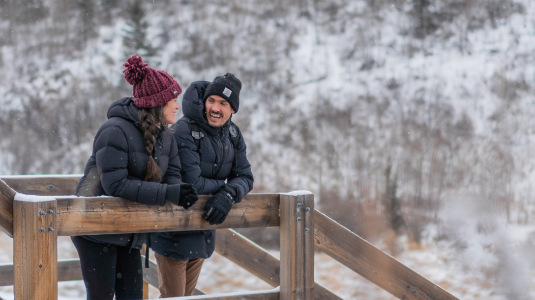 a couple looks at the winter scenery on outdoor stairs
