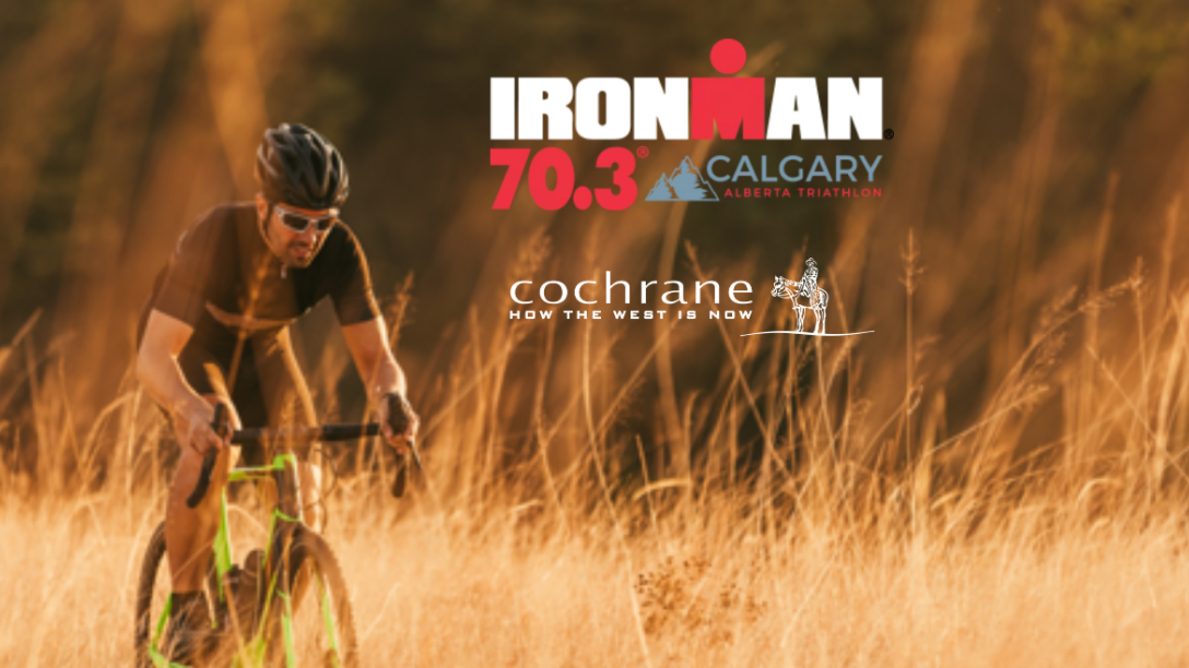 Cyclist on a hill with ironman and town logos 