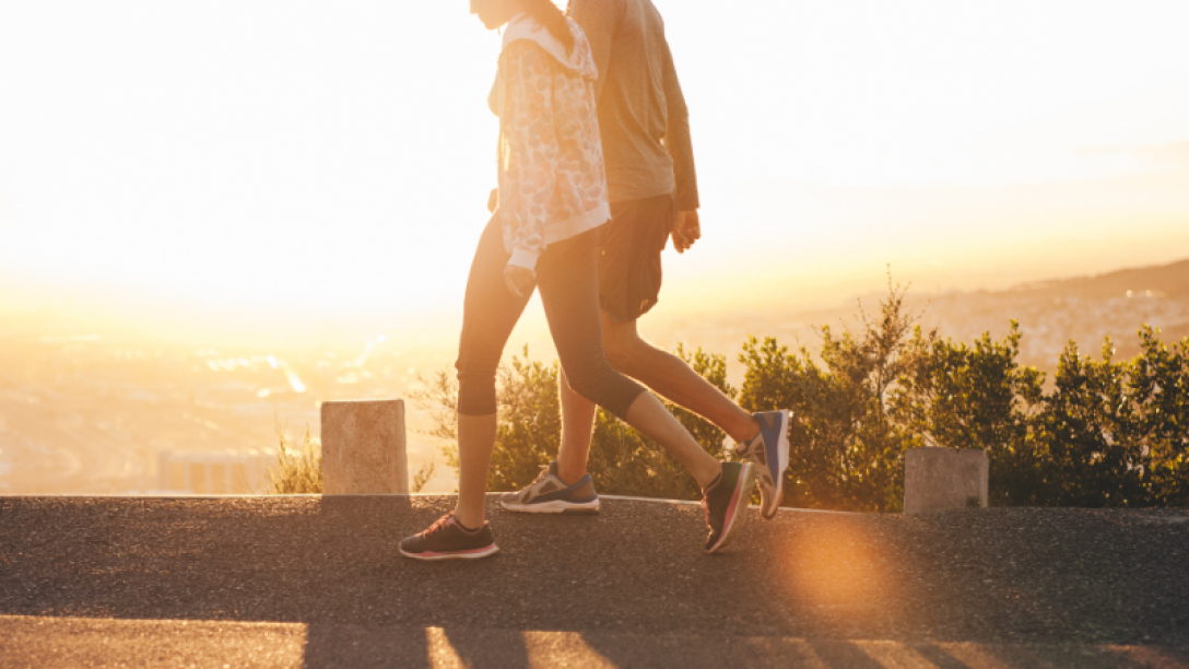 image of two people walking during a sunset