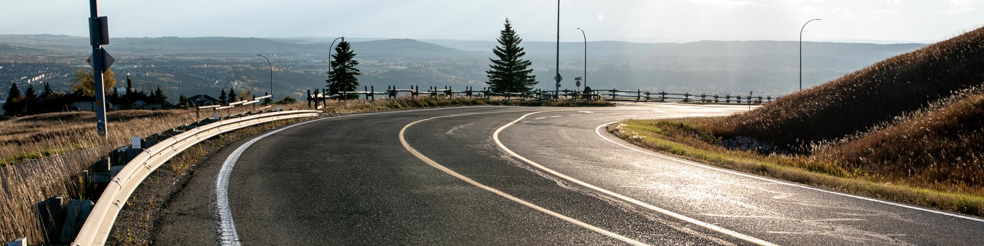 winding road with sun glaring off of it 