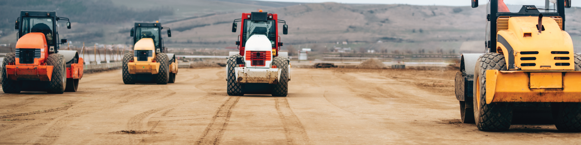 heavy machinery flattering a road for paving