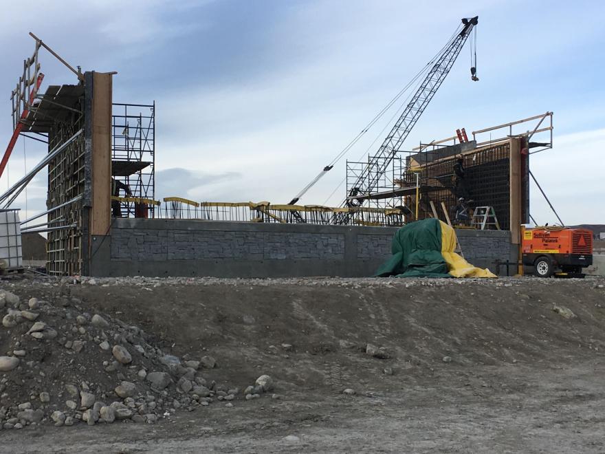 Side view of bridge abutment under construction. Exposed rebar can be seen at the site..