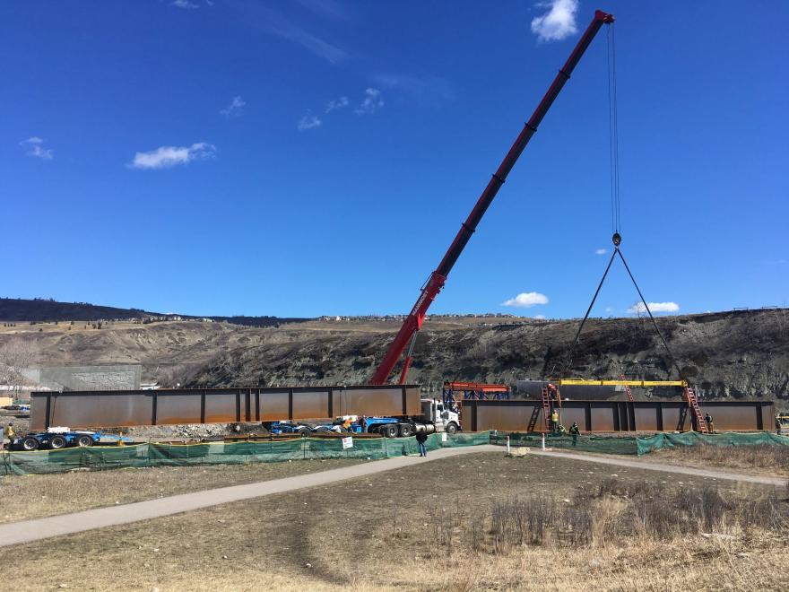 Construction crane unloading material near bridge site.
