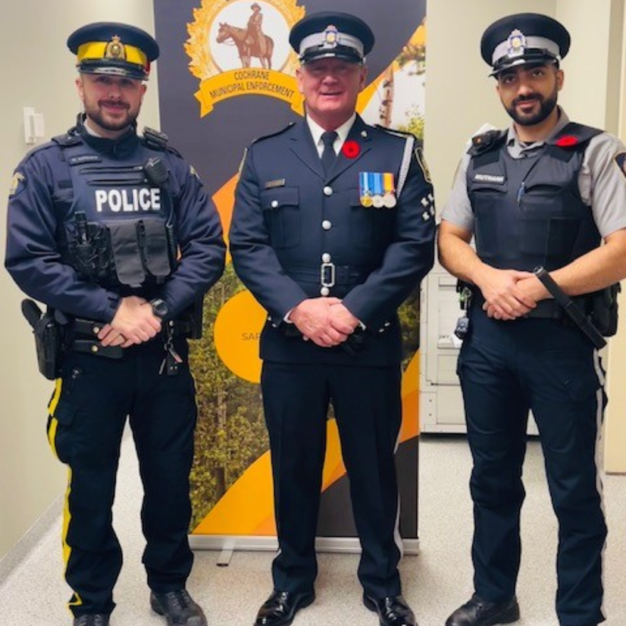 three officers posing in front of banner