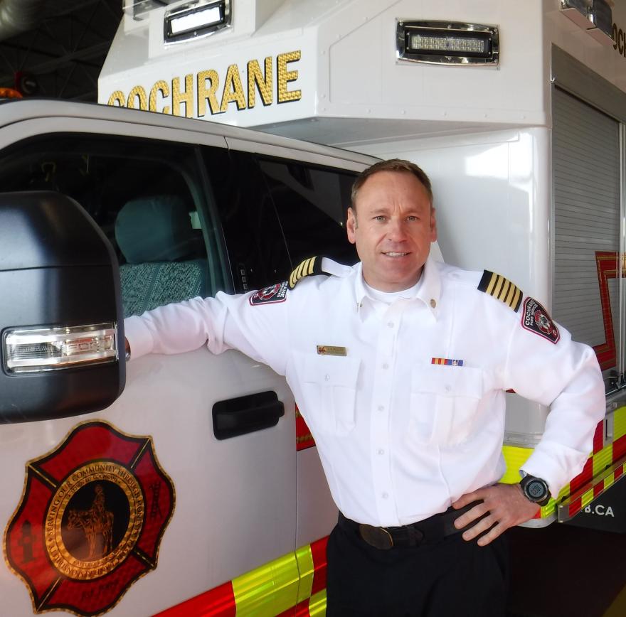 image of fire chief polley in front of fire services vehicle 