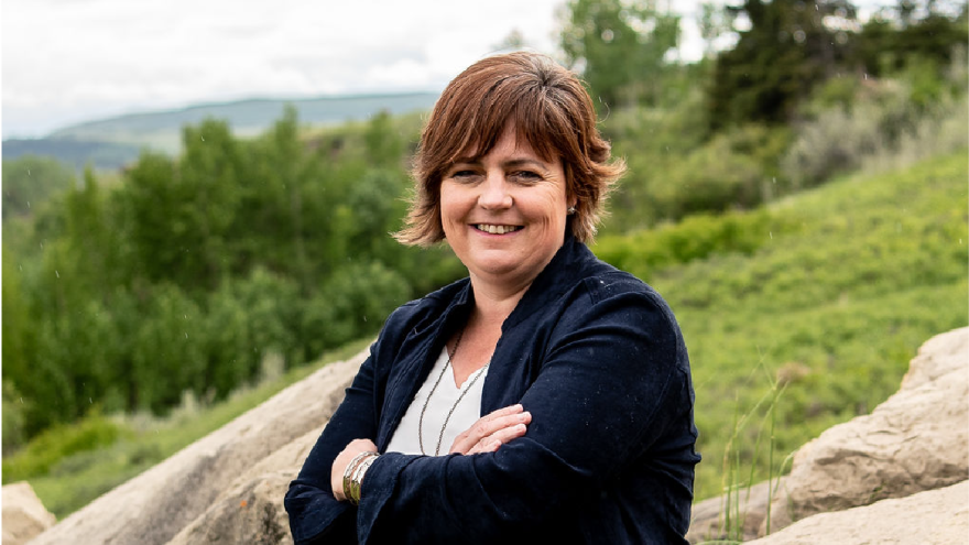 Councillor McFadden smiling to camera with green background