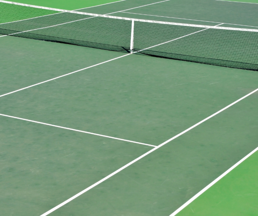 close up of green tennis court with lines and net