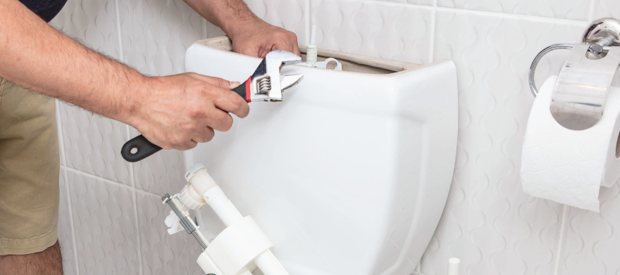 man fixing toilet