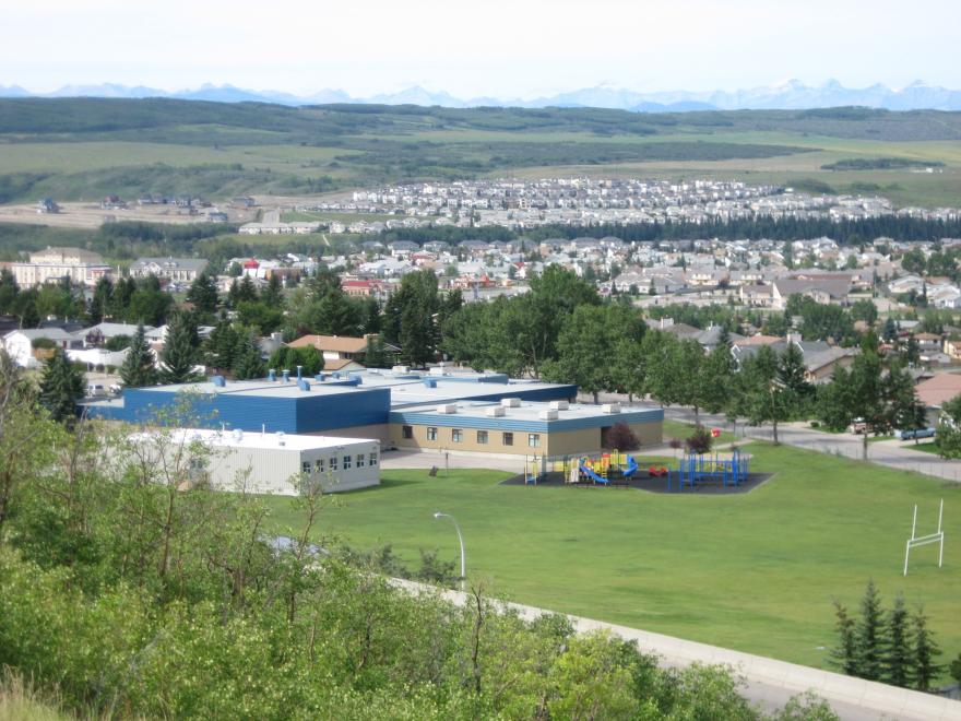 zoomed out image of school, sports field and neighbouhood in the back. 