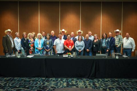 Group photo of Cochrane's council. There are men and women standing behind a long table.