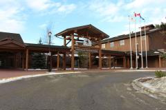 Exterior of Cochrane RancheHouse. The RancheHouse is a large wooden building. Its entrance has a large wooden sign with the name of the building on it.